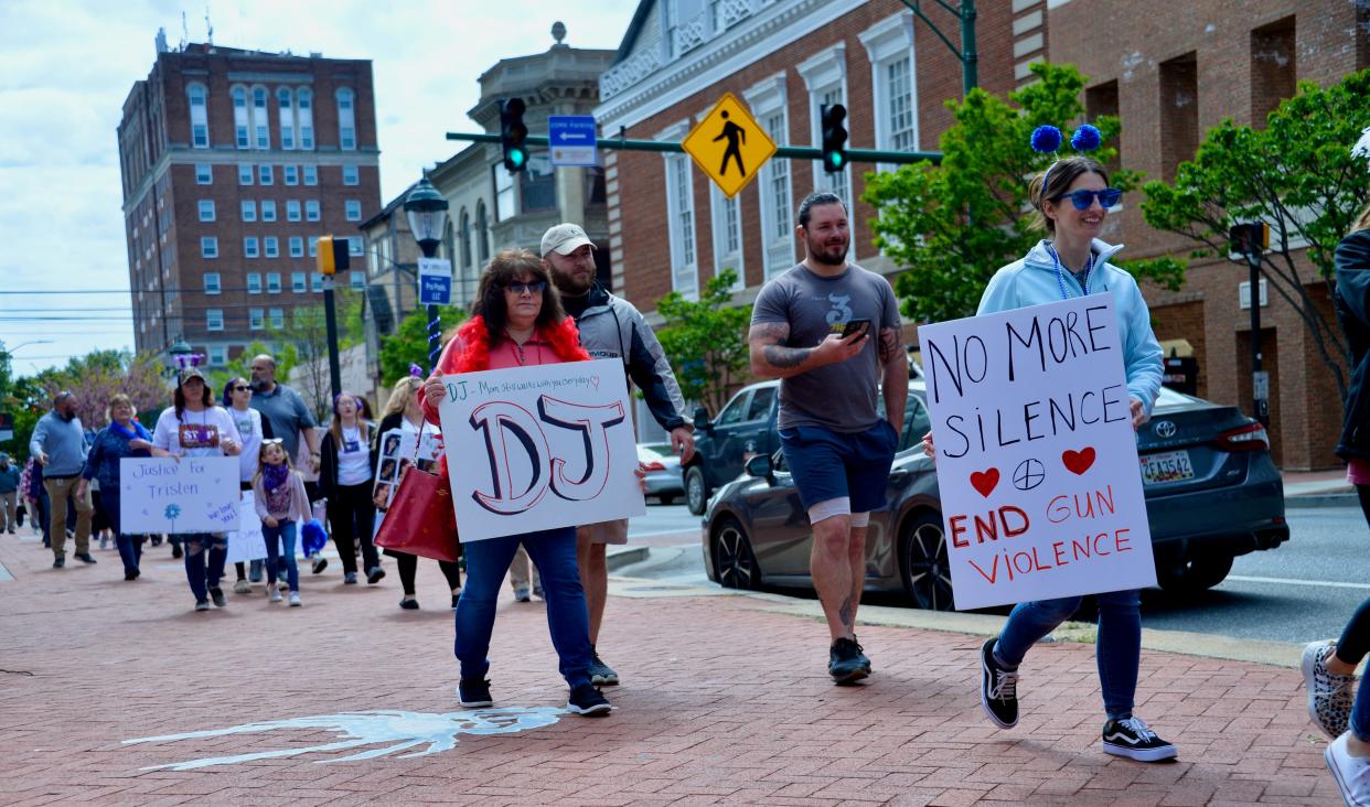 Participants in a National Crime Victims' Rights Week walk pass University Plaza on East Washington Street as they traveled through the downtown Hagerstown area on Friday to raise awareness.