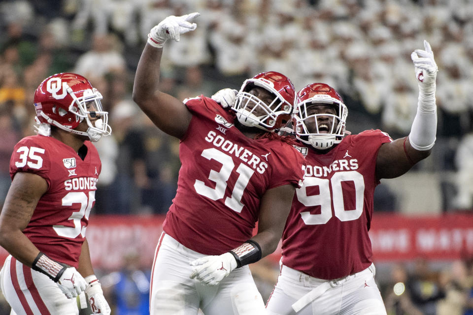 Oklahoma defensive tackle Jalen Redmond (31), defensive lineman Neville Gallimore (90) and linebacker Nik Bonitto (35) celebrate Redmond's sack of Baylor quarterback Gerry Bohanon during the second half of an NCAA college football game for the Big 12 Conference championship, Saturday, Dec. 7, 2019, in Arlington, Texas. (AP Photo/Jeffrey McWhorter)