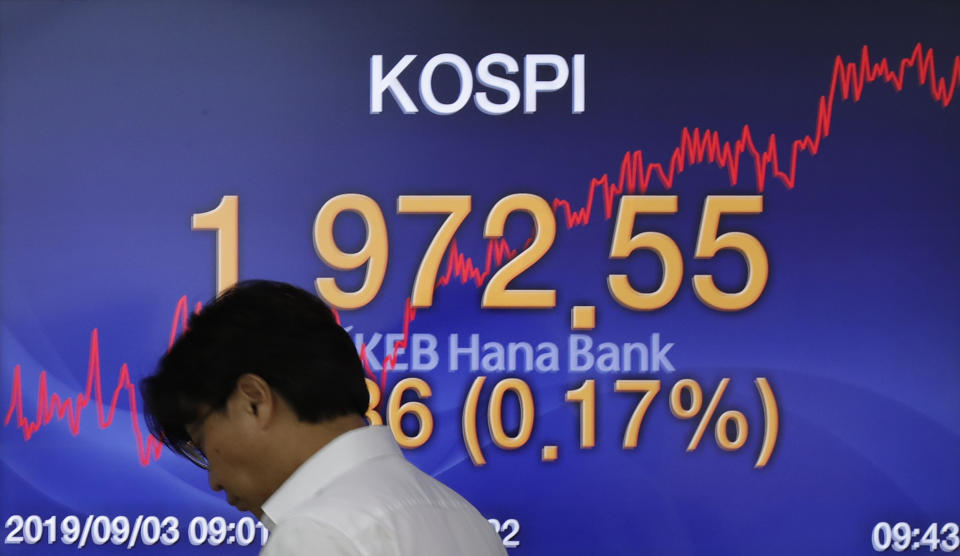 A currency trader walks by the screen showing the Korea Composite Stock Price Index (KOSPI) at the foreign exchange dealing room in Seoul, South Korea, Tuesday, Sept. 3, 2019. Asian stock markets were mostly lower Tuesday after investor jitters over U.S.-Chinese trade tension were revived by a report negotiators cannot agree on a schedule for talks this month. (AP Photo/Lee Jin-man)