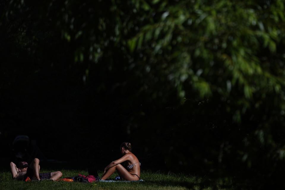 People enjoy the sun on a beach at Serebryany Bor park in Moscow, Russia, Thursday, July 11, 2024. Warm weather has settled in Moscow with a temperature of 30 Celsius, (86 Fahrenheit) and will increase in the coming days. (AP Photo/Pavel Bednyakov)