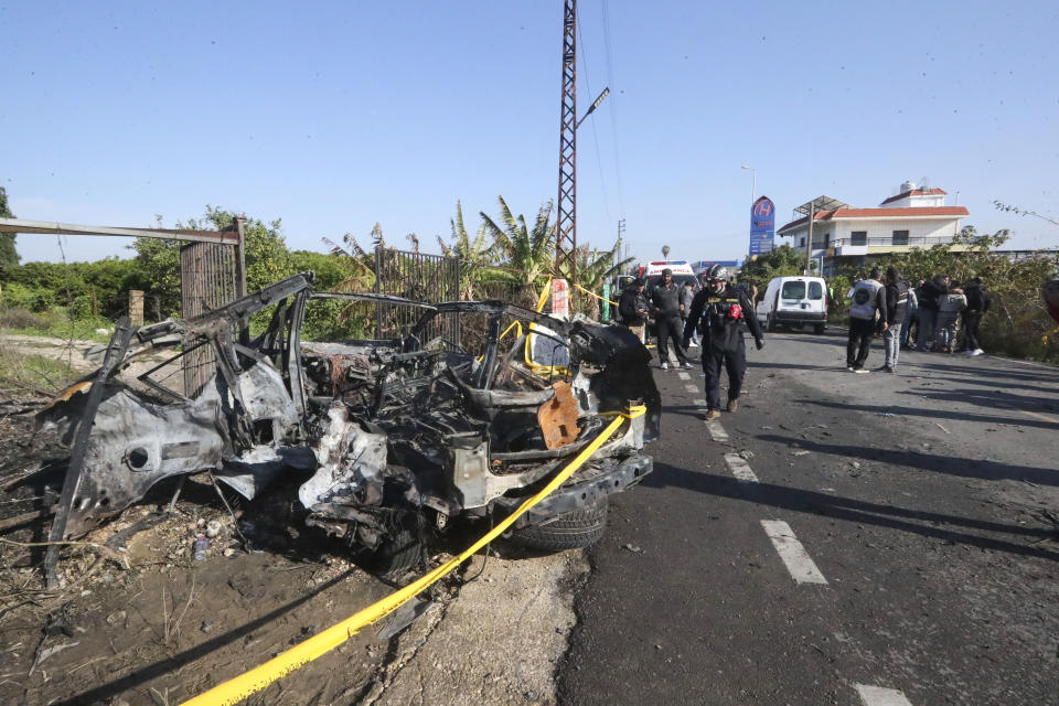 Civil defense worker searches a damaged car in the southern town of Bazouriyeh, Lebanon, Saturday, Jan. 20, 2024. An Israeli drone strike on the car near the Lebanese southern port city of Tyre killed two people, the state-run National News Agency reported. (AP Photo/Mohammad Zaatari)