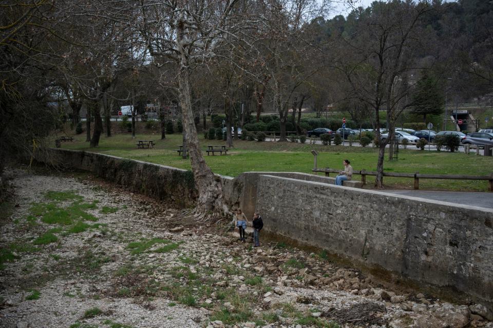 Children play in a dried riverbed in Flassans-sur-Issole, southern France, Wednesday, March 1, 2023. France recorded 32 days without rain this winter – the longest such winter drought since record-keeping began in 1959.