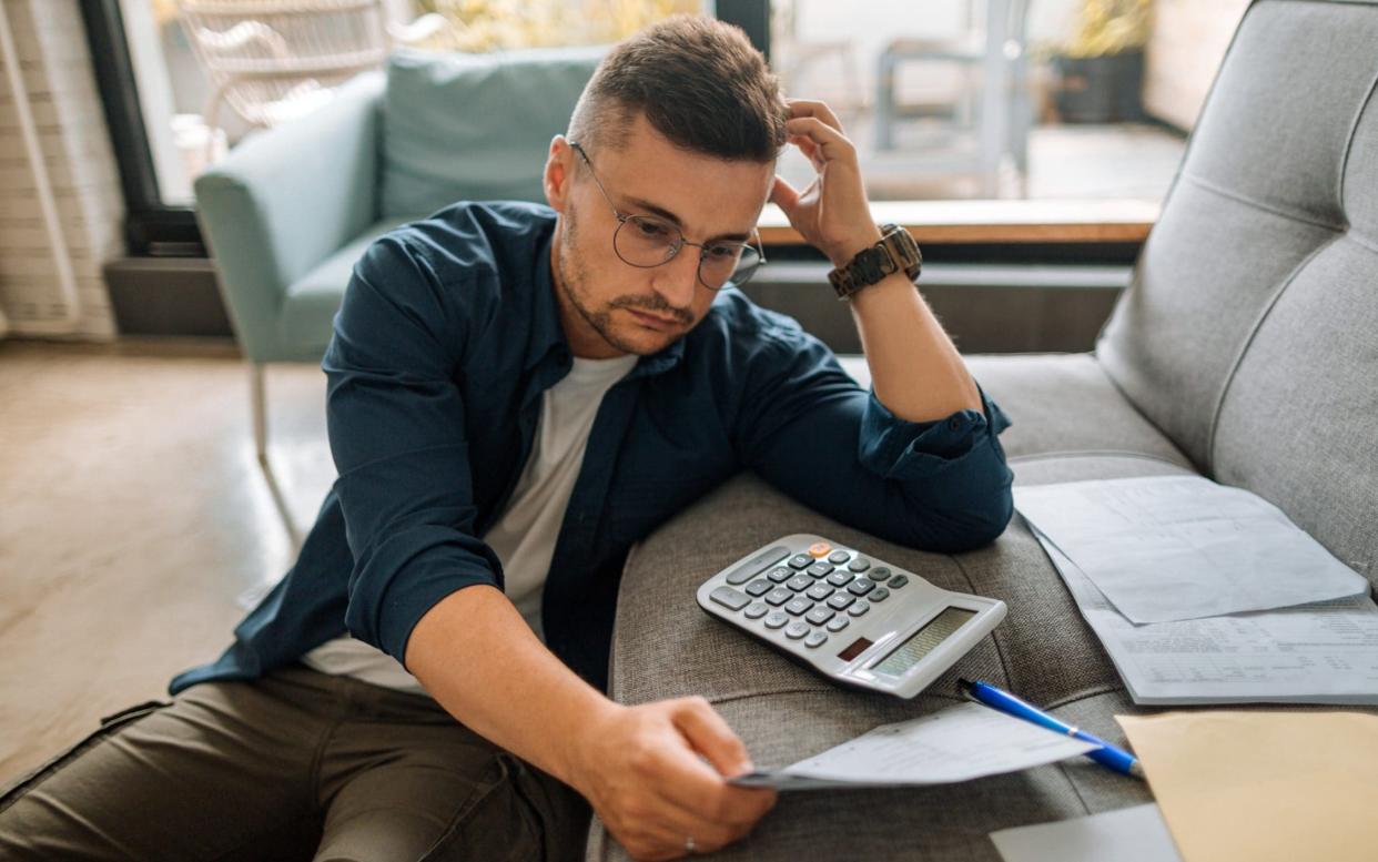 Young man at home, checking his bills