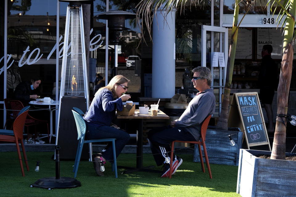 Patrons dine outside of a restaurant along the Coast Highway 101 in Encinitas, Calif., on Friday, Dec. 18, 2020. (AP Photo/Ringo H.W. Chiu)