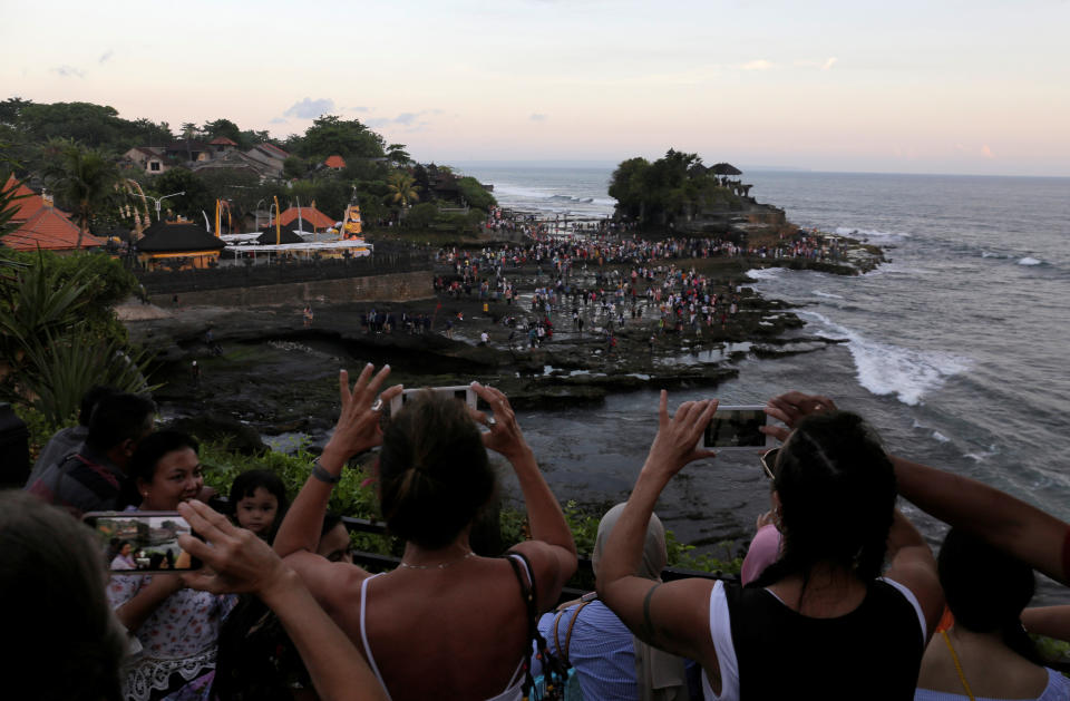 Tourists take pictures of the Hindu temple Tanah Lot (R) in Tabanan, on the resort island of Bali, Indonesia May 6, 2018. (Photo: Johannes Christo / Reuters)