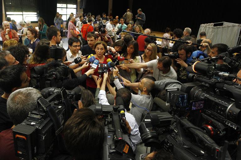 Leader of 'Barcelona en Comu' (Barcelona in Common) party and candidate for mayor of Barcelona Ada Colau (C) votes at a polling station in Barcelona on May 24, 2015