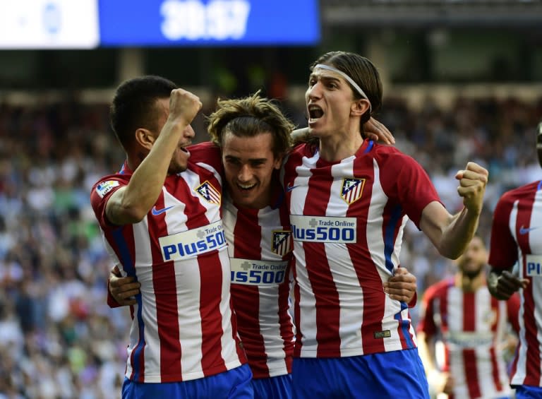 Atletico Madrid's forward Antoine Griezmann (C) celebrates with midfielder Angel Correa (L) and defender Filipe Luis after scoring a goal during the Spanish league football match against Real Madrid on April, 8, 2017