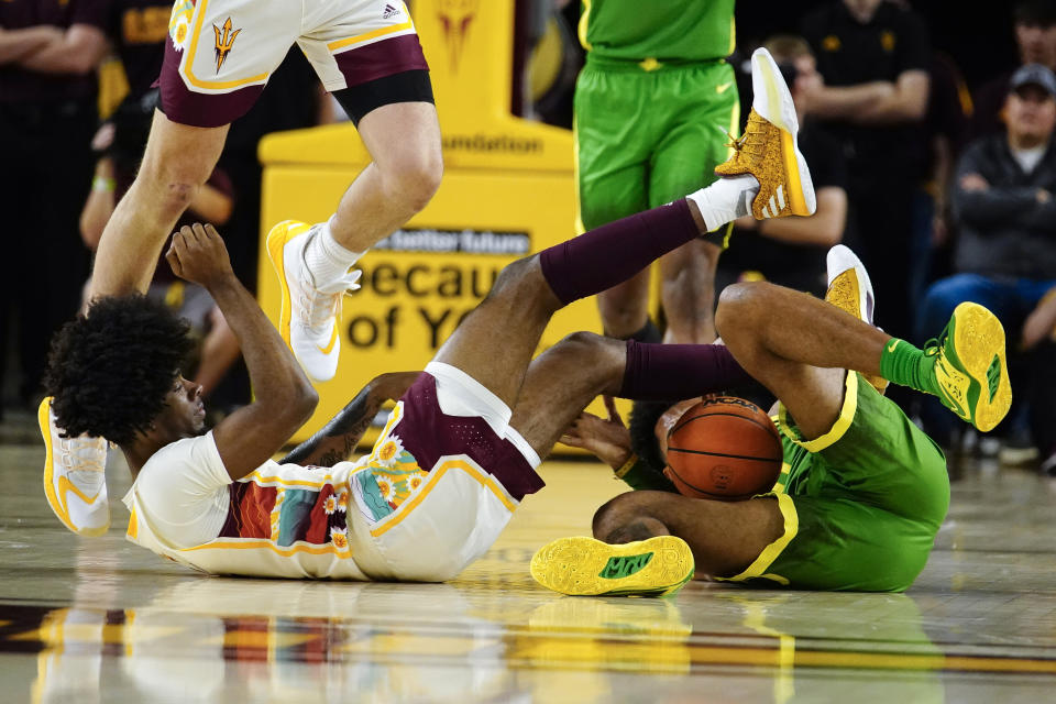 Arizona State's Jamiya Neal, left, falls after battling for the ball with Oregon's Rivaldo Soares, right, during the first half of an NCAA college basketball game, Saturday, Feb. 4, 2023, in Tempe, Ariz. (AP Photo/Darryl Webb)