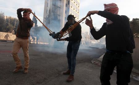 Palestinian protesters use a large slingshot to hurl stones towards Israeli troops during clashes in the West Bank city of Bethlehem November 27, 2015. REUTERS/Abdelrahman Younis