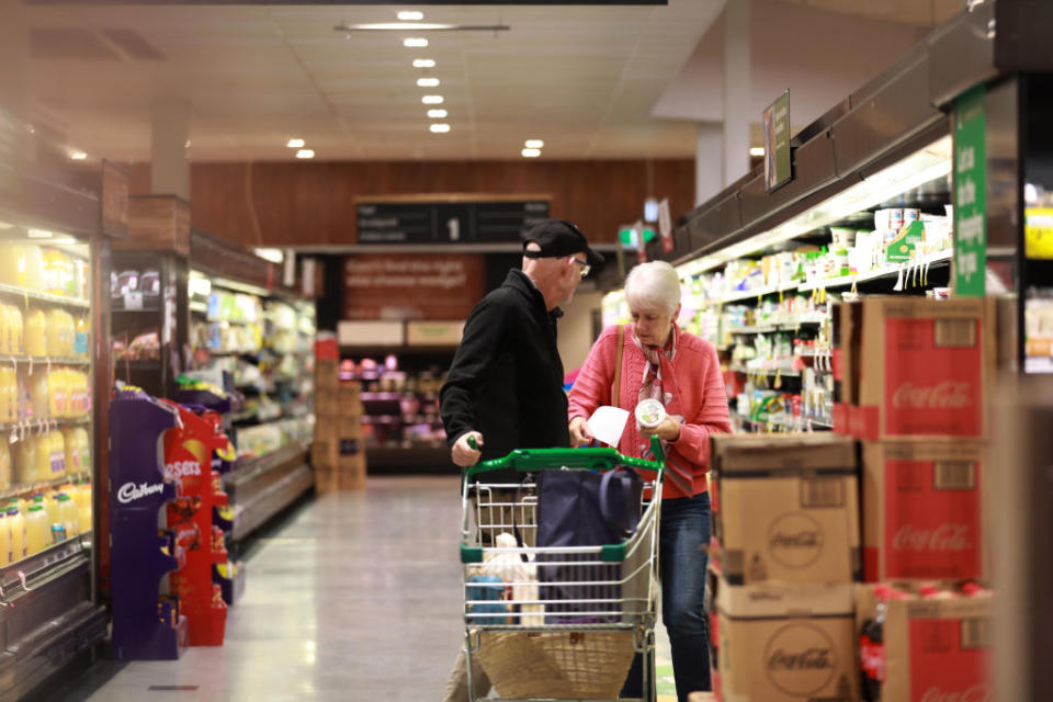 Pictured is an elderly couple shopping in a Woolworths supermarket aisle. 