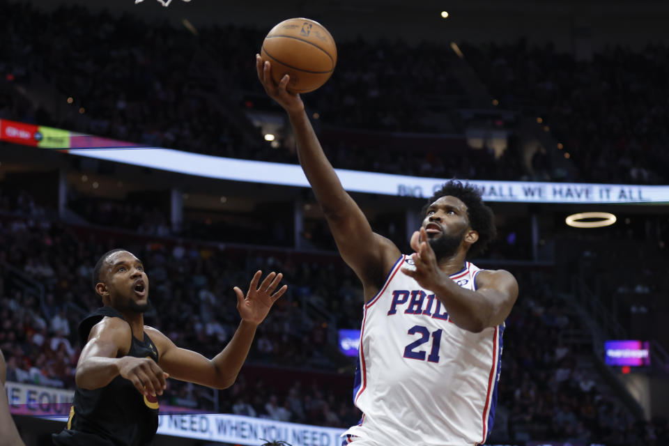 Philadelphia 76ers center Joel Embiid (21) shoots against Cleveland Cavaliers forward Evan Mobley during the second half of an NBA basketball game, Wednesday, March 15, 2023, in Cleveland. (AP Photo/Ron Schwane)