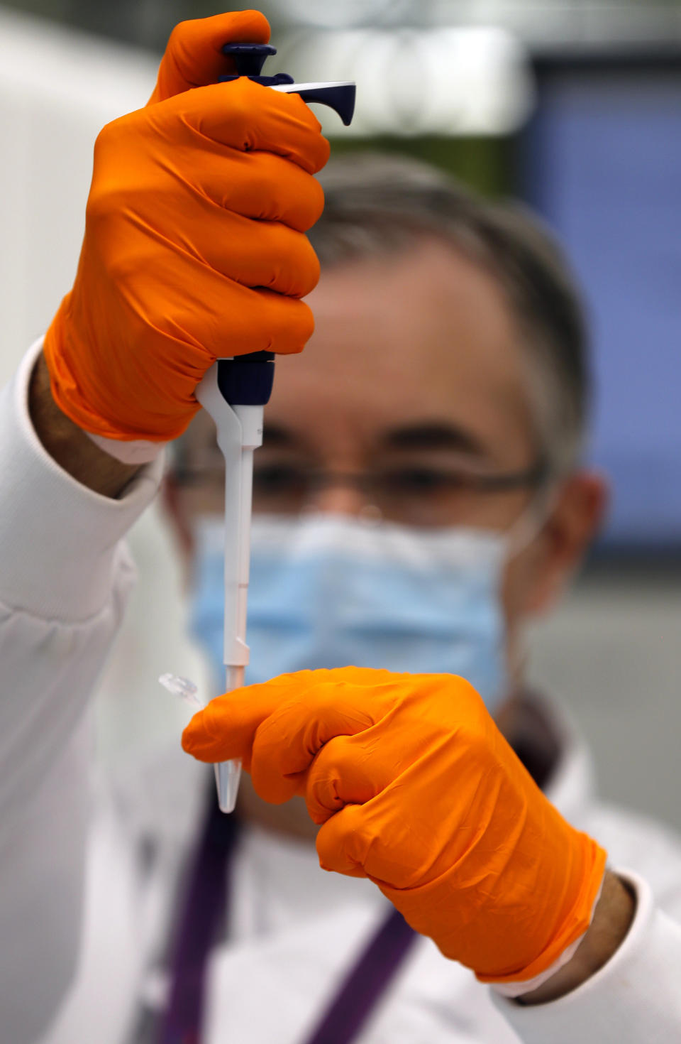 A lab assistant uses a pipette to prepare Coronavirus RNA for sequencing at the Wellcome Sanger Institute that is operated by Genome Research in Cambridge, Thursday, March 4, 2021. Cambridge University microbiologist Sharon Peacock understood that genomic sequencing would be crucial in tracking the coronavirus, controlling outbreaks and developing vaccines, so she began working with colleagues around the country to put together a plan when there were just 84 confirmed cases in the country. The initiative helped make Britain a world leader in rapidly analyzing the genetic material from large numbers of COVID-19 infections, generating more than 40% of the genomic sequences identified to date.(AP Photo/Frank Augstein)