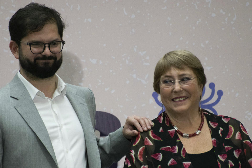 Chilean President Gabriel Boric, left, and former President Michelle Bachelet, applaud during a ceremony marking human rights month in Santiago, Chile, Monday, Dec. 12, 2022. (AP Photo/Matias Basualdo)