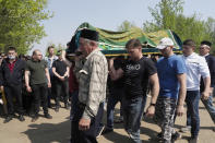 Men carry a coffin of Elvira Ignatieva, an English language teacher, in Kazan, Russia, Wednesday, May 12, 2021, who was killed at a school shooting on Tuesday. Russian officials say a gunman attacked a school in the city of Kazan and Russian officials say several people have been killed. Officials said the dead in Tuesday's shooting include students, a teacher and a school worker. Authorities also say over 20 others have been hospitalised with wounds. (AP Photo/Dmitri Lovetsky)