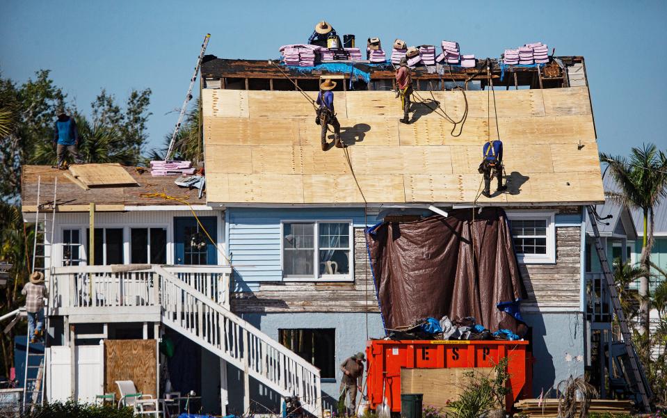 Workers replace a roof on a Fort Myers Beach home on Tuesday, April 18, 2023. Hurricane Ian decimated the Island when it slammed ashore on Sept. 28, 2022. Thousands of structures in Southwest Florida were affected. This storm is one of the reasons insurance rates are skyrocketing.