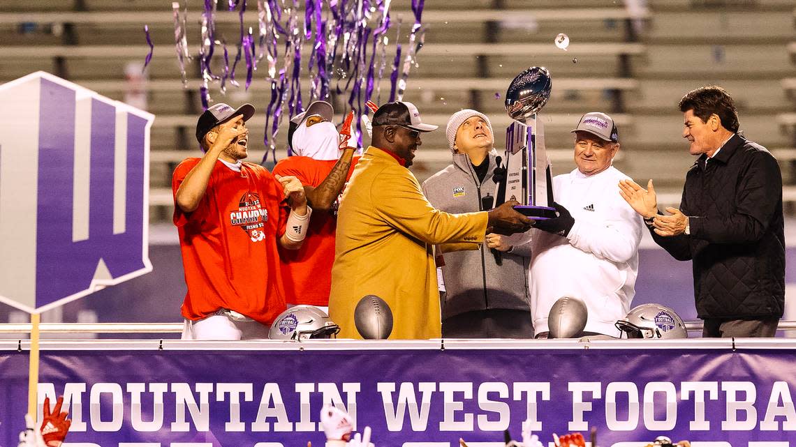 Fresno State athletics director Terry Tumey and coach Jeff Tedford accept the Mountain West Conference football championship trophy from outgoing MWC Commissioner Craig Thompson. FOX broadcasater Petros Papadakis emceed the presentation. Fresno State defeated Boise State 28-16 for the Mountain West title on Saturday, Dec. 3, 2022 at Albertsons Stadium.