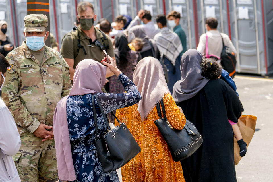 People evacuated from Afghanistan step off a bus as they arrive at a processing center in Chantilly, Monday, Aug. 23, 2021, after arriving on a flight at Dulles International Airport. (AP Photo/Andrew Harnik)