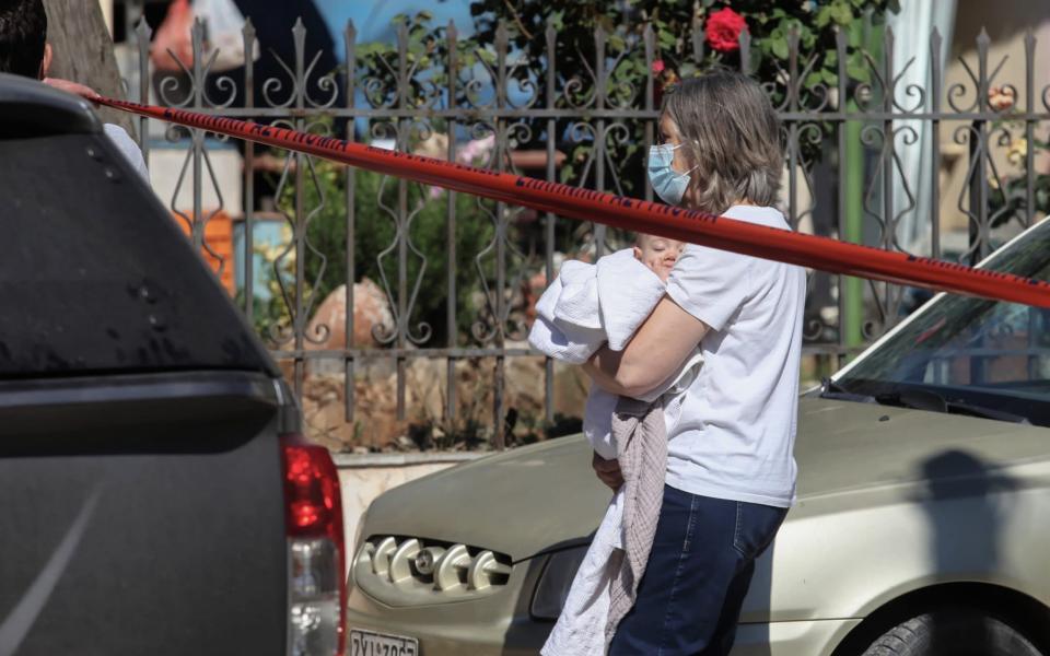 A young baby is removed away from the property in Glyka Nera in the outskirts of Athens - John Liakos/Intime News/Athena Pictures /Athena Picture Agency Ltd 