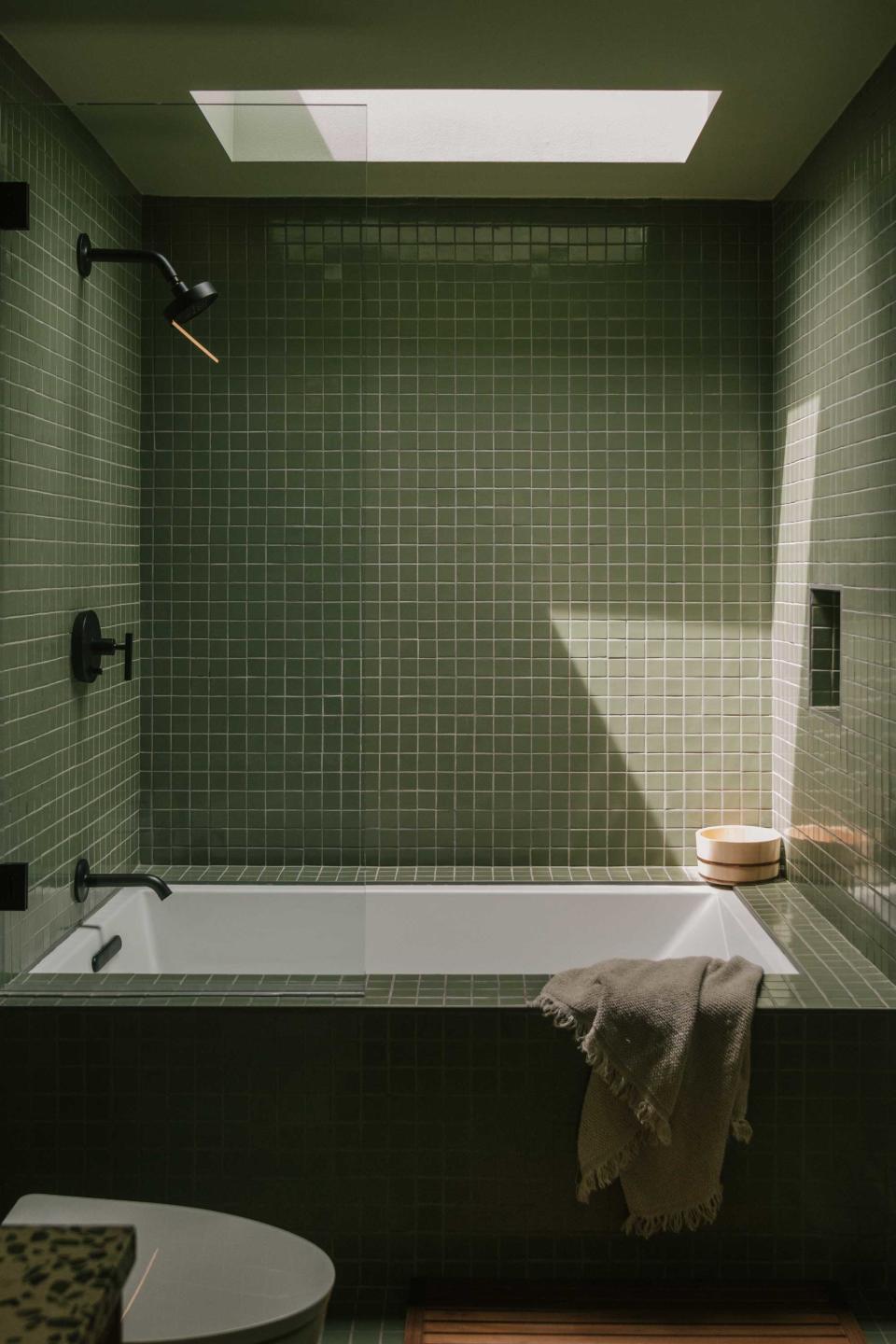 a green tiled built in bathtub