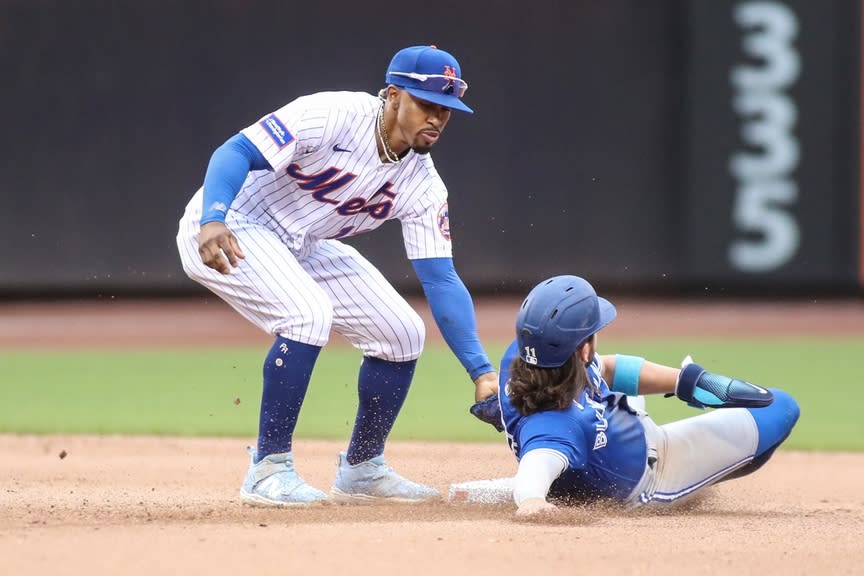 El campocorto de los Mets de Nueva York, Francisco Lindor (12), elimina al campocorto de los Azulejos de Toronto, Bo Bichette (11), en la quinta entrada en el Citi Field.