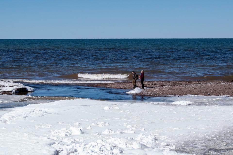 Visitors of the state park stand near the mouth of the Presque Isle River where it meets Lake Superior on March 23, 2024. Roughly 500,000 people visit Porcupine Mountain Wilderness State Park in Michigan's Upper Peninsula each year. The Copperwood Mine, which is slated to become the closest metallic mine to Lake Superior to date, will sit just west of the state park.