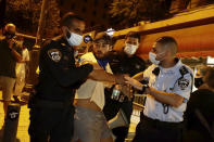 Israeli police officers detain a protester during a demonstration against Israeli Prime Minister Benjamin Netanyahu near the Prime Minister's residence in Jerusalem, Sunday, Sept. 20, 2020. (AP Photo/Sebastian Scheiner)