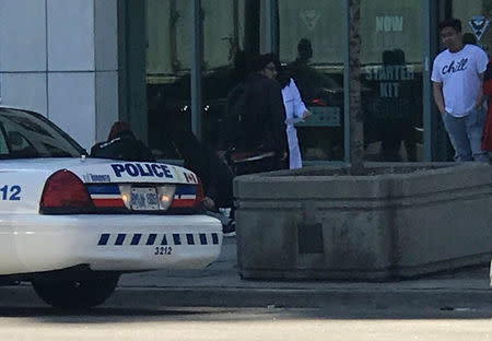 A victim is helped by pedestrians after a van hit multiple people at a major intersection in Toronto, Canada April 23, 2018, in this picture obtained by REUTERS