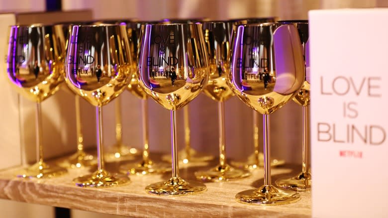 Several 'Love Is Blind' branded gold wine glasses 
