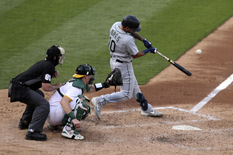 Seattle Mariners' Tim Lopes, right, hits an RBI-single against the Oakland Athletics during the third inning of the second baseball game of a doubleheader in Oakland, Calif., Saturday, Sept. 26, 2020. (AP Photo/Jed Jacobsohn)