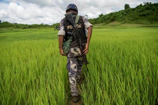 A Myanmar border guard walks near a mass grave discovered in violence-wracked Rakhine state in September 2017