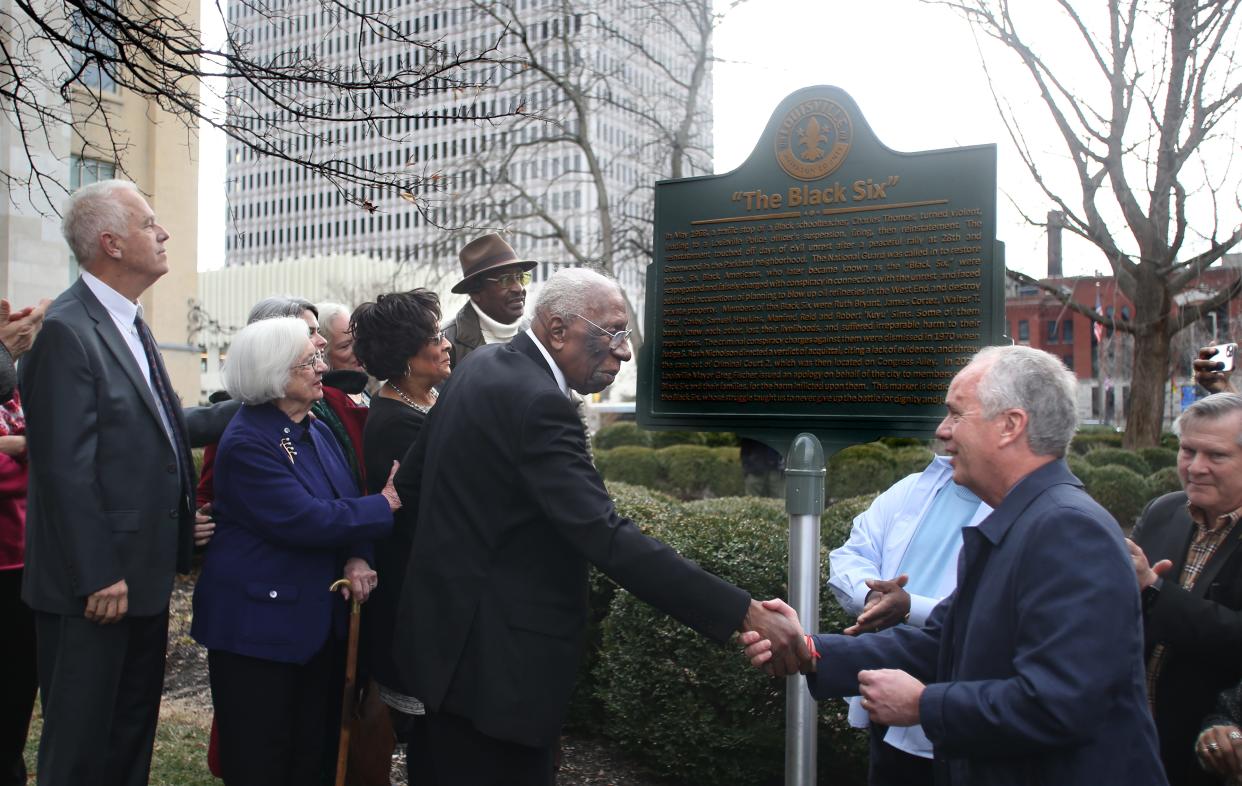 Mayor Greg Fischer shakes the hand if Manfred Reid Sr. at the unveiling of a historical marker in honor of the Louisville Black Six. A group of business people and activists falsely accused in 1968 of plotting to destroy buildings in the West End. Dec. 30, 2022
