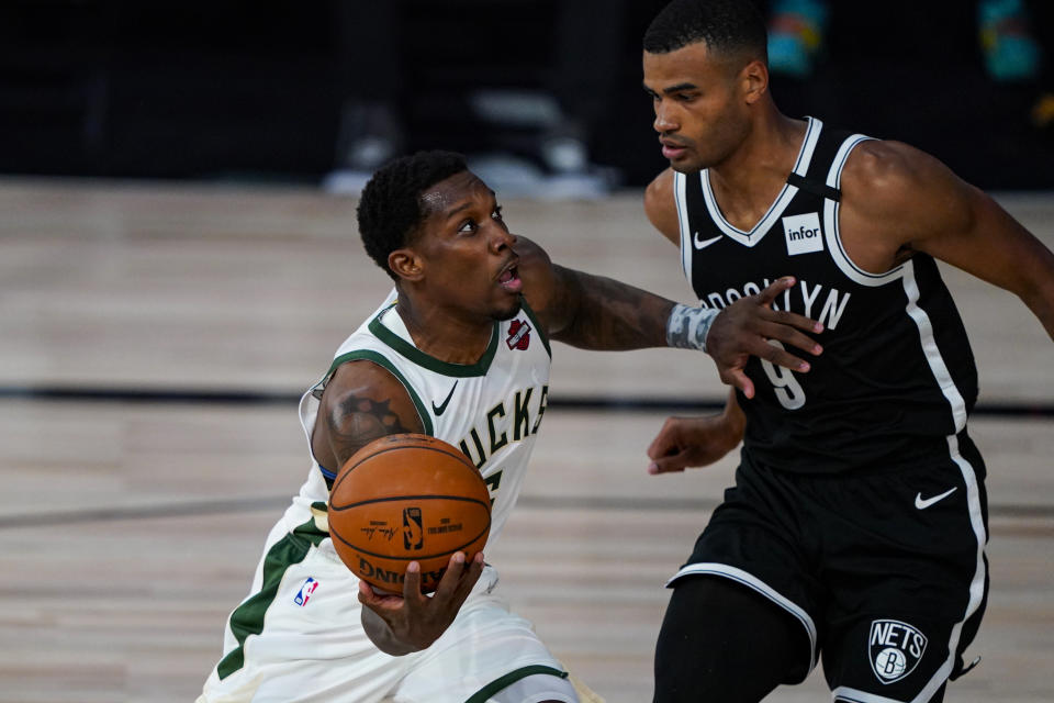 Milwaukee Bucks guard Eric Bledsoe (6) drives on Brooklyn Nets guard Timothe Luwawu-Cabarrot (9) during the second half of an NBA basketball game Tuesday, Aug. 4, 2020 in Lake Buena Vista, Fla. (AP Photo/Ashley Landis)