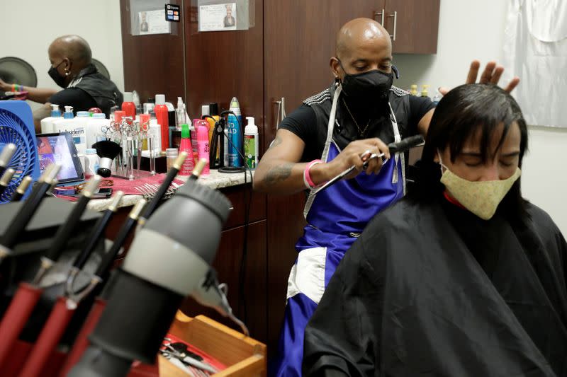 FILE PHOTO: Gary Connell cuts a customer's hair in the aftermath of a nine-week disruption to his hairstyling business due to the stay-at-home order for the coronavirus disease (COVID-19) outbreak, at Salon Plaza in Wheaton, Maryland