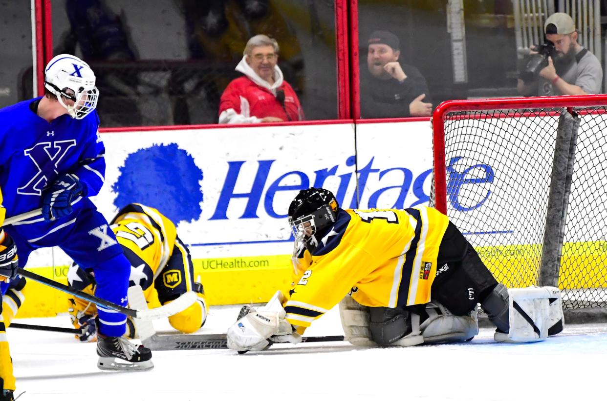 Moeller goalie Noah Smith makes a glove save for the Crusaders in their 3-1 win over St. Xavier in a Greater Catholic League-South hockey matchup at Heritage Bank Center, Jan. 21, 2023.