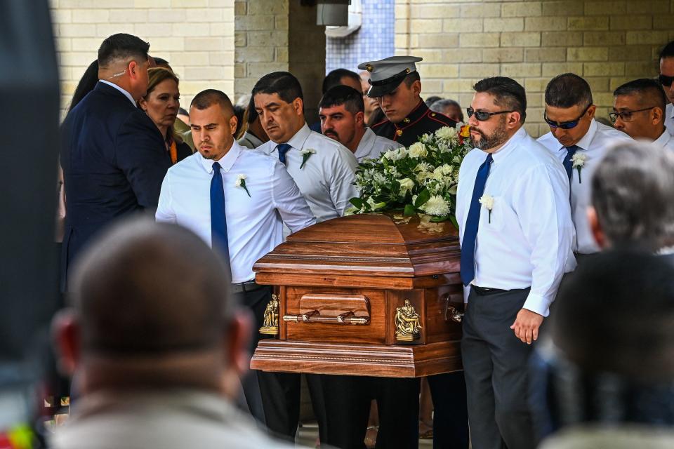 A group of men carry a casket