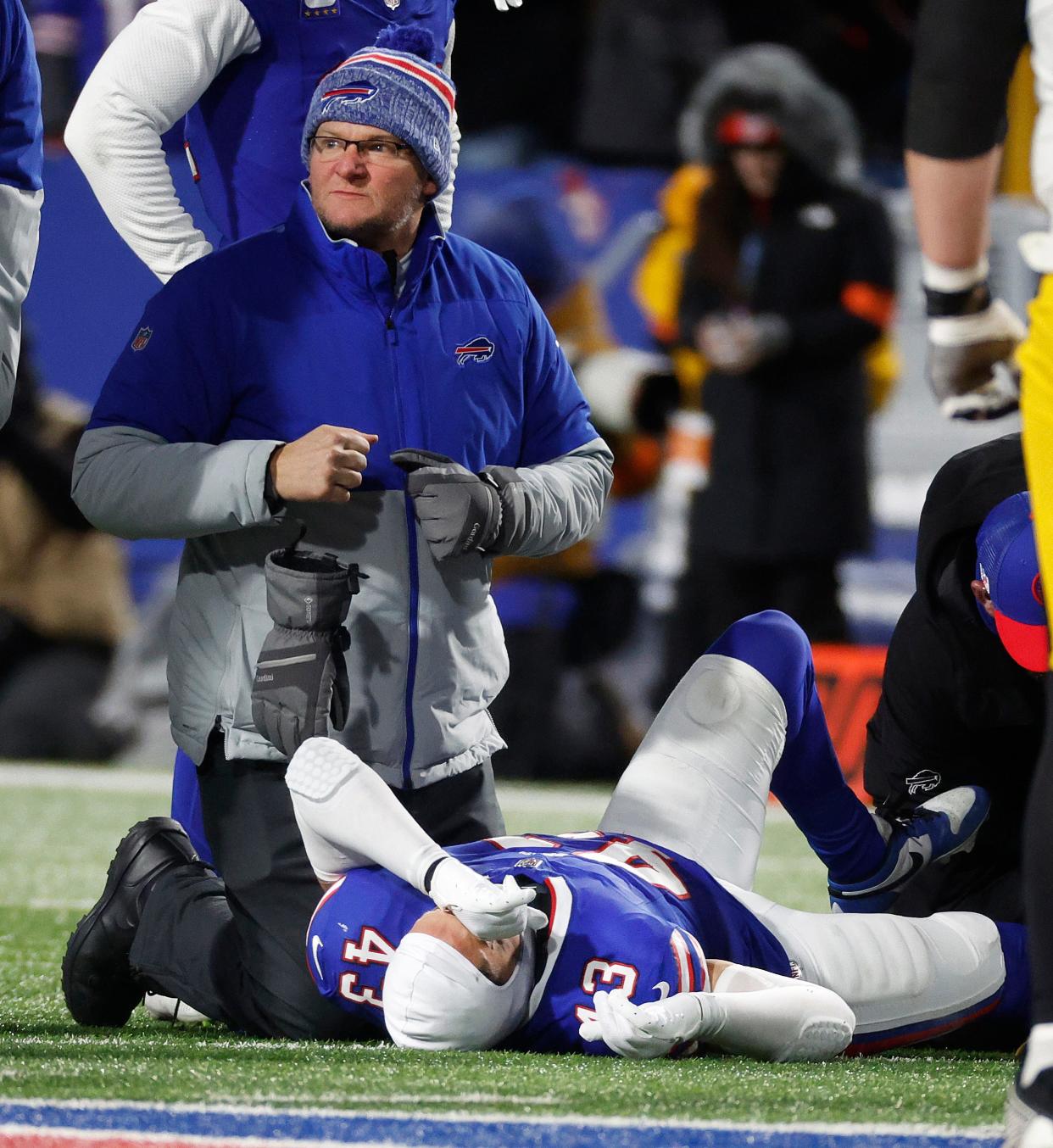 A trainer treating Buffalo Bills linebacker Terrel Bernard (43) after he was injured making a tackle.