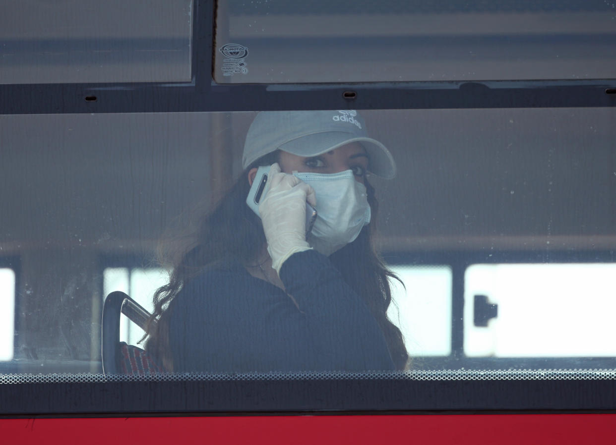 A woman on a bus wearing a face mask and latex gloves on Westminster Bridge, London, as the UK continues in lockdown to help curb the spread of the coronavirus. (Photo by Yui Mok/PA Images via Getty Images)