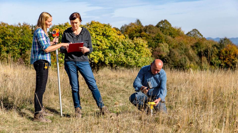 Surveyors Finishing Measurements and Hammering Boundary Marker.