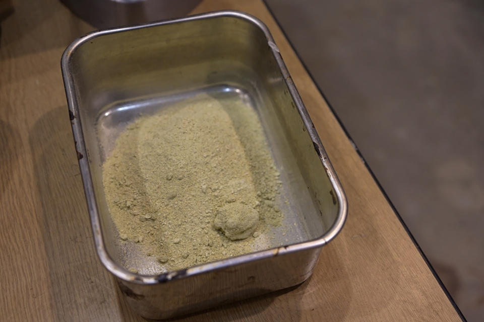 Particles of dried cabbage that were pulverized in a mixer are seen at the laboratory of Tokyo University in Tokyo, on May 26, 2022. The university's researchers Kota Machida and Yuya Sakai have developed a technology that can transform food waste into “cement" for construction use. (AP Photo/Chisato Tanaka)