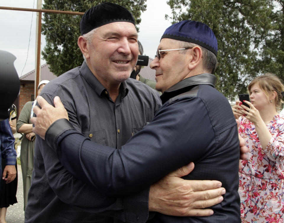 Oyub Titiev, the head of a Chechnya branch of the prominent human rights group Memorial, right, embraces a friend as he leaves a prison in Argun, Russia, Friday, June 21, 2019. Titiyev was released from a Russian prison on Friday morning, more than 18 months after first being detained on drug charges his supporters say were fabricated. (AP Photo/Musa Sadulayev)