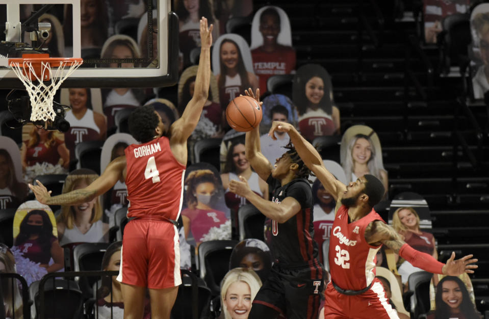 Temple's Khalif Battle (0) takes a shot under the defense on Houston's Justin Gorham (4) and Reggie Chaney (32) in the first half of an NCAA college basketball game, Saturday, Jan. 23, 2021, in Philadelphia. (AP Photo/Michael Perez)