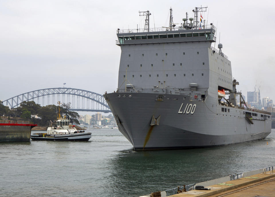 In this photo provided by the Australian Department of Defense, HMAS Choules departs from a fleet base in Sydney, Wednesday, Jan. 1, 2020. Australia is deploying military ships to help communities ravaged by wildfires that destroyed homes and sent thousands of residents and holidaymakers fleeing to the shoreline. (ABIS Benjamin Ricketts/ADF via AP)
