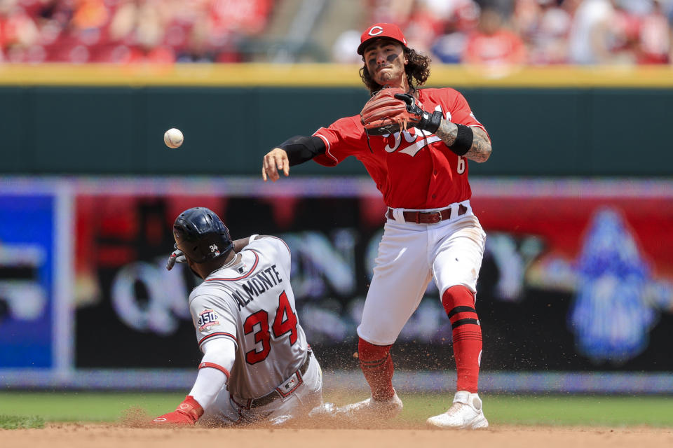 Atlanta Braves' Abraham Almonte, left, is forced out at second base as Cincinnati Reds' Jonathan India, right, fields the ball and throws to first base during the fourth inning of a baseball game in Cincinnati, Sunday, June 27, 2021. (AP Photo/Aaron Doster)