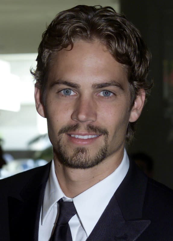 FILE PHOTO: FILE PHOTO: Actor Paul Walker poses for photographs while arriving at the Hollywood Film Festival, August 6, 200..