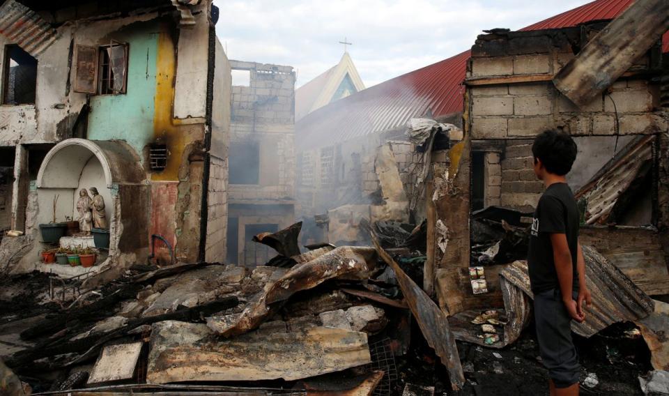 <p>Ein Junge in Manila betrachtet Häuser, die durch ein Feuer komplett zerstört wurden. (Bild: Erik De Castro/Reuters) </p>