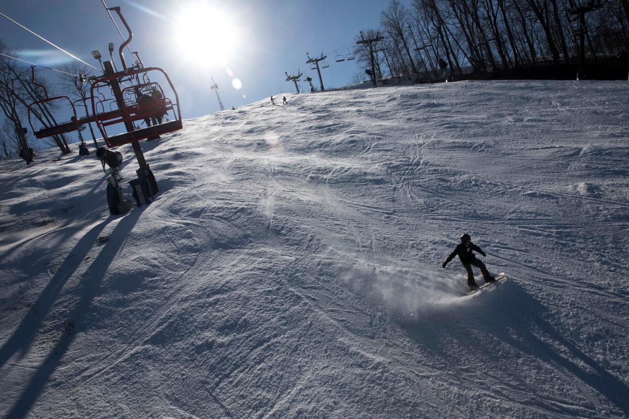 A snowboard cuts through the snow at Perfect North Slopes in 2021.