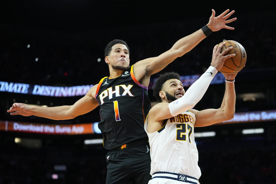 Phoenix Suns guard Devin Booker (1) blocks the shot of Denver Nuggets guard Jamal Murray (27) during the second half of Game 6 of an NBA basketball Western Conference semifinal series, Thursday, May 11, 2023, in Phoenix. The Nuggets eliminated the Sun in their 125-100 win. (AP Photo/Matt York)