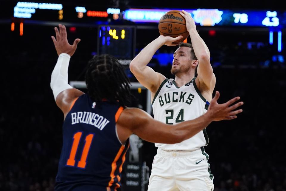 Milwaukee Bucks' Pat Connaughton (24) shoots a 3-point basket over New York Knicks' Jalen Brunson (11) during the second half of an NBA basketball game Monday, Jan. 9, 2023, in New York. (AP Photo/Frank Franklin II)