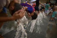 <p>People cool off with water from a fountain during a hot summer day, in the basque city of Vitoria, northern Spain, Saturday, Aug. 4, 2018. (Photo: Alvaro Barrientos/AP) </p>