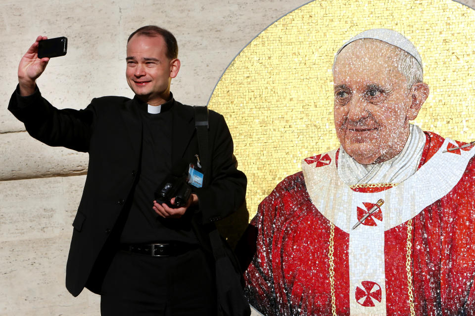 VATICAN CITY, VATICAN - DECEMBER 04:  A priest takes a picture of himself near mosaic featuring the icon of Pope Francis stands at the 'Arco delle Campane' to receive the blessing of the Pontiff before it will be placed in St. Paul's Basilica on December 4, 2013 in Vatican City, Vatican. At the end of his General Audience Pontiff called on everyone to pray for a group of nuns taken by force from the Greek Orthodox Monastery of Saint Tecla in the ancient Christian town of Ma'loula in Syria.  (Photo by Franco Origlia/Getty Images)